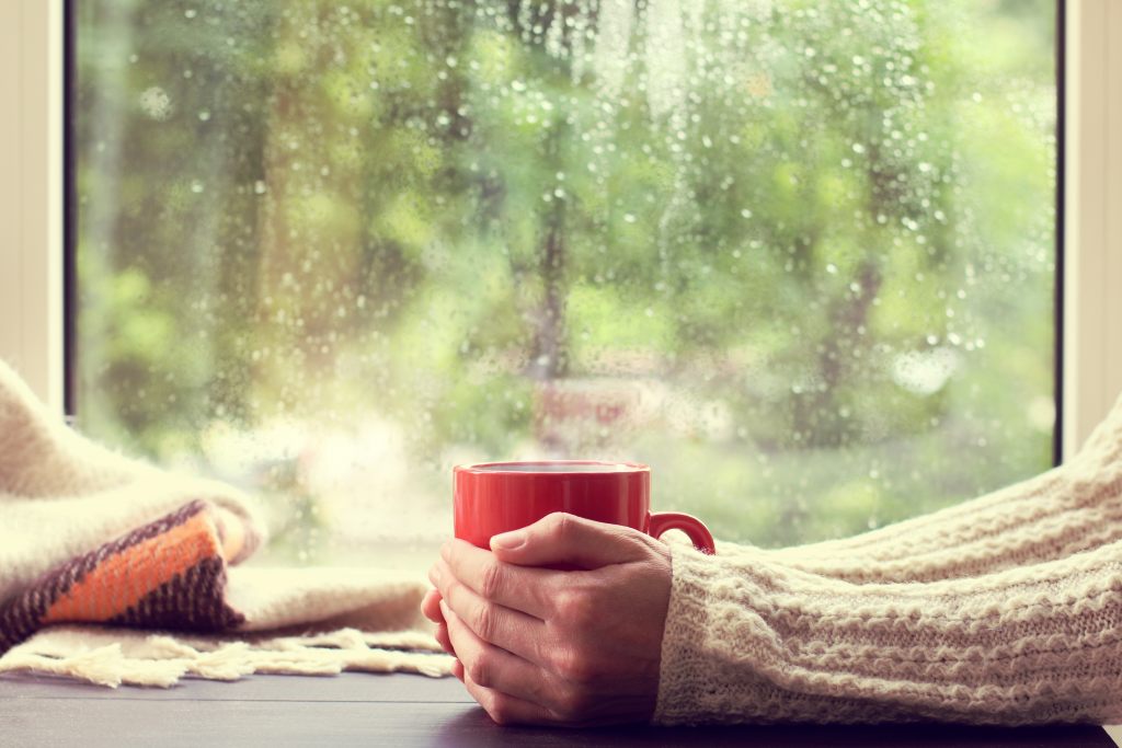 kubek-herbata-okno-deszcz-dłonie-zimno-uszczelnienie-ciepły-napój
